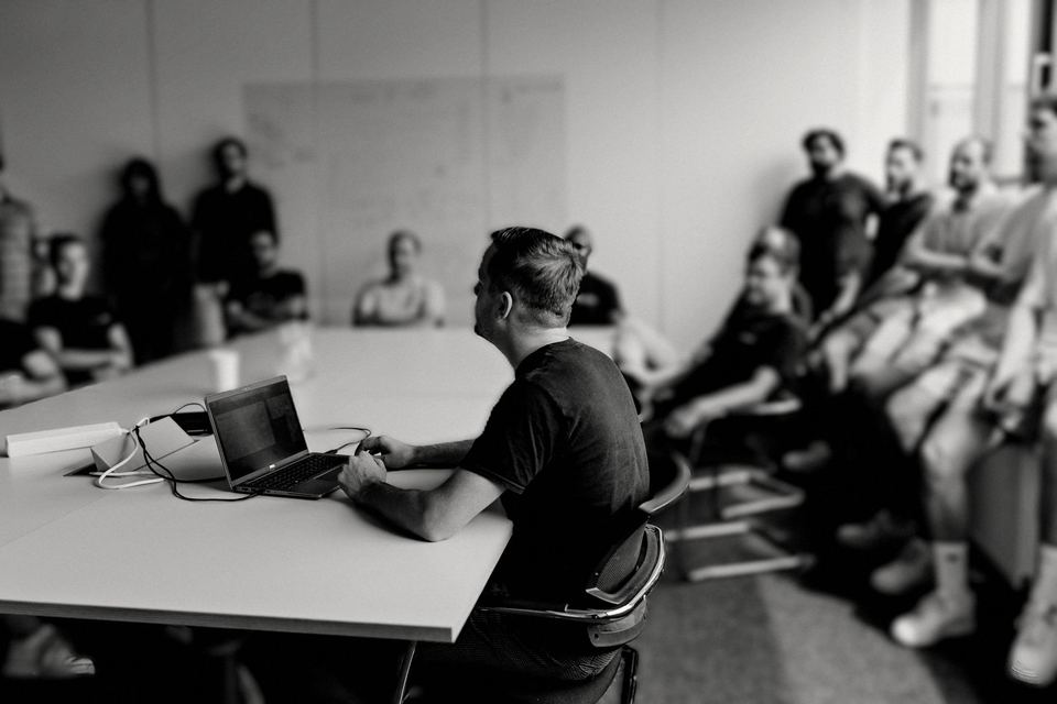 Team-Briefing am Konferenztisch, Zuhörende im Halbkreis